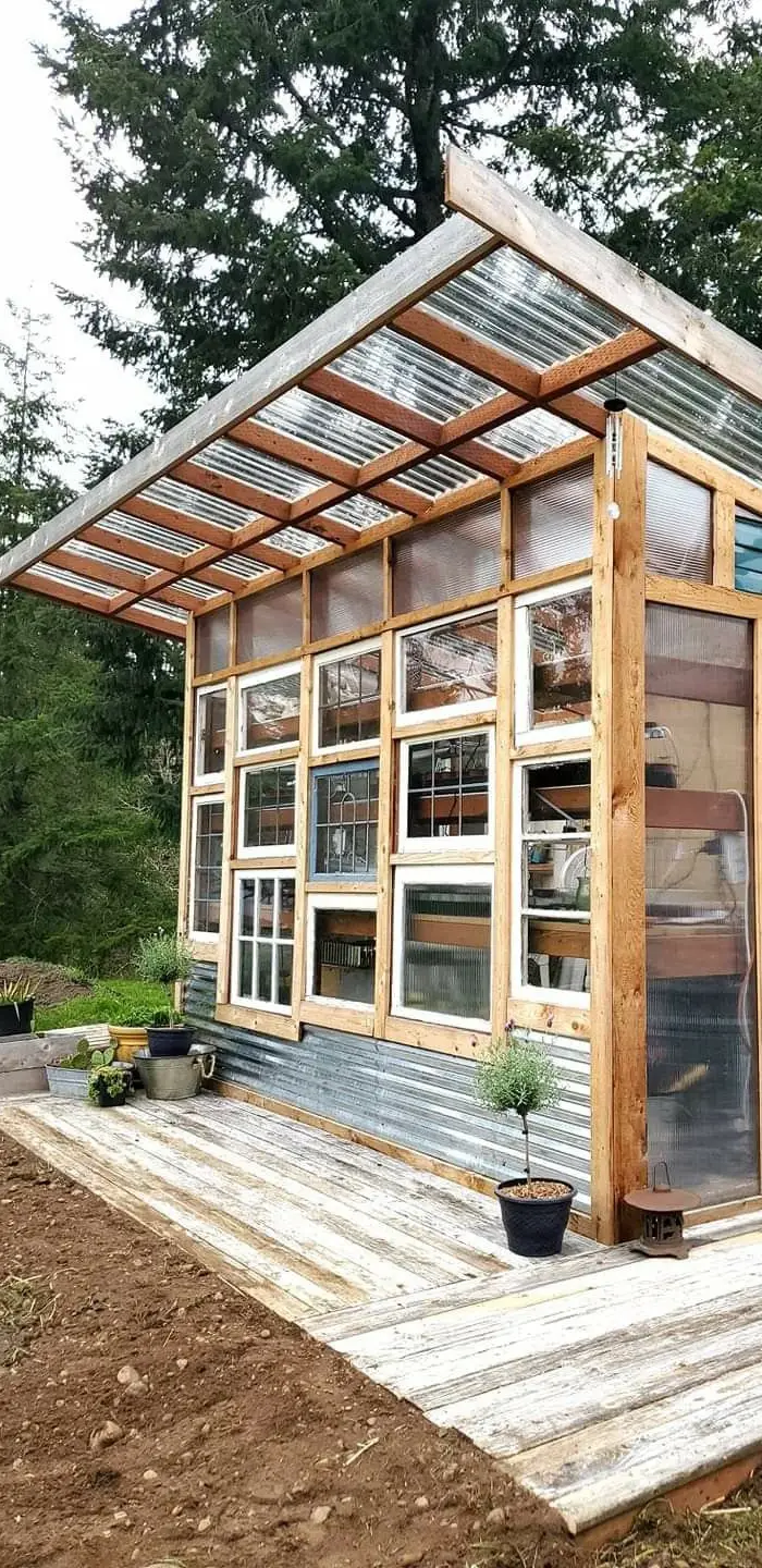 Une serre en bois et vitrée dans un jardin