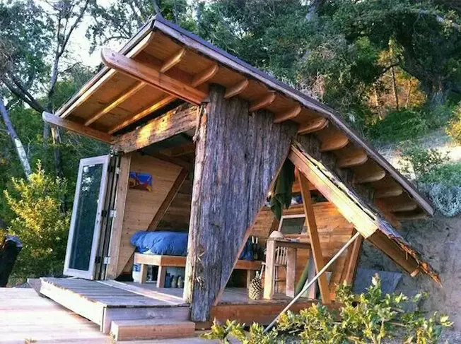 une cabane pour dormir dans un jardin, en bois de réemploi