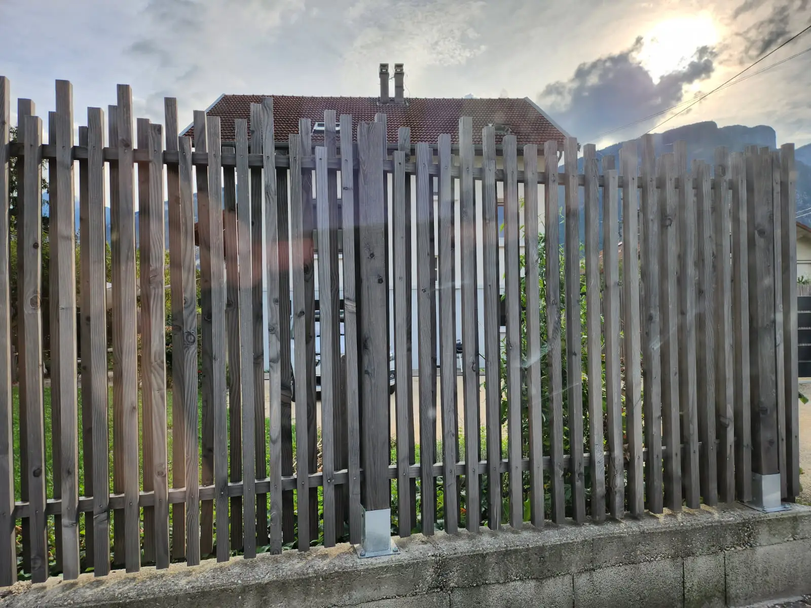 une palissade devant une maison en bois de réemploi