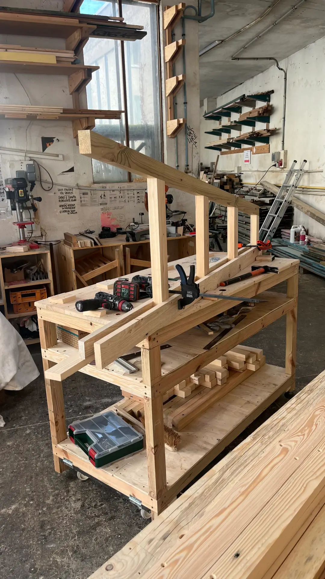 l'intérieur de l'atelier avec une étagère en bois de réemploi en construction